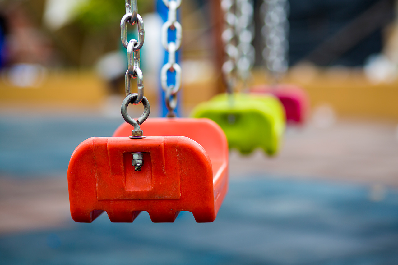 lose up of empty swing in a playground